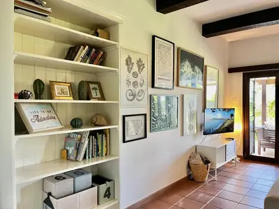 a room with shelves with books and a television at STAY Perla House in Protaras