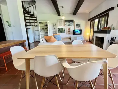 a dining room with a wooden table and white chairs at STAY Perla House in Protaras