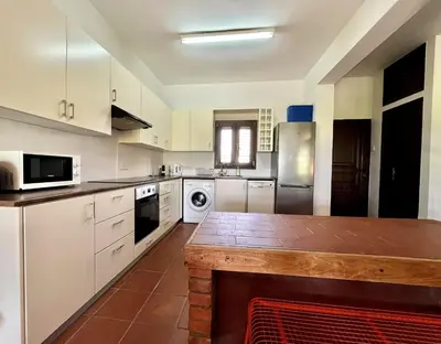 a kitchen with white cabinets and a wooden counter top at STAY Perla House in Protaras