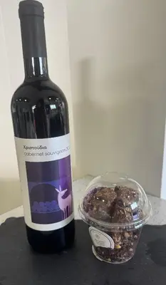 a bottle of wine next to a bowl of nuts at Blue Tulip - Strovolos in Kato Lakatamia