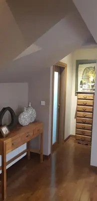 an attic room with a wooden table and a dresser at Live in landlord guest house panthea in Limassol