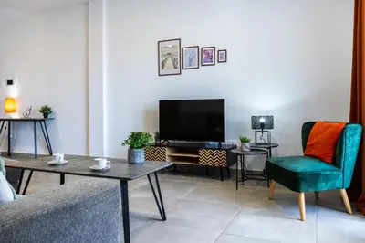 a living room with a couch and a tv at Invictus 2-Bedroom Apartment in Larnaka