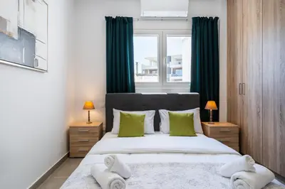 a bedroom with a large bed with green curtains at Invictus 2-Bedroom Apartment in Larnaka