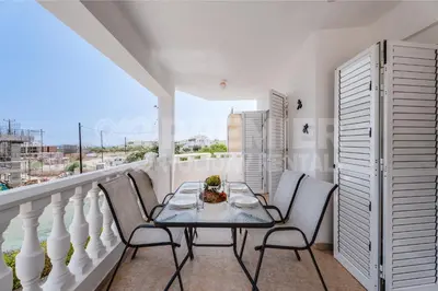 a dining room with a table and chairs on a balcony at Apartment Karlota in Paralimni