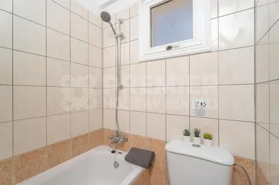 a bathroom with a tub and a toilet and a window at Apartment Karlota in Paralimni