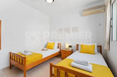 two beds in a bedroom with yellow and white at Apartment Karlota in Paralimni