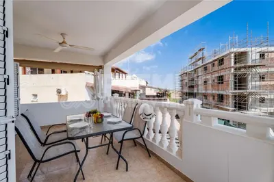 a balcony with a table and a view of a building at Apartment Karlota in Paralimni
