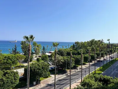 a street lined with palm trees next to the ocean at Seaview Apartment in Limassol in Limassol