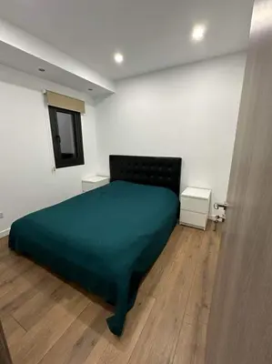 a bedroom with a bed with a green blanket at Great Escape -Holiday House in Larnaka