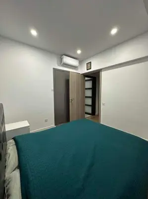 a bedroom with a large bed with a green blanket at Great Escape -Holiday House in Larnaka