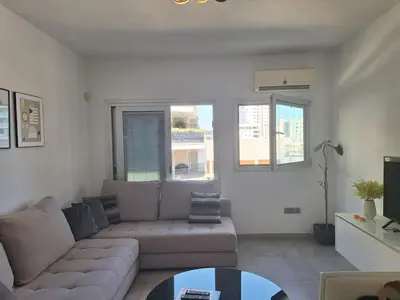 a living room with a couch and a table at Oceanside Living - Modern 1 bedroom in Limassol