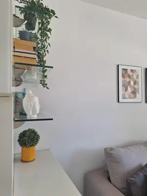 a living room with a couch and a shelf with books at Oceanside Living - Modern 1 bedroom in Limassol