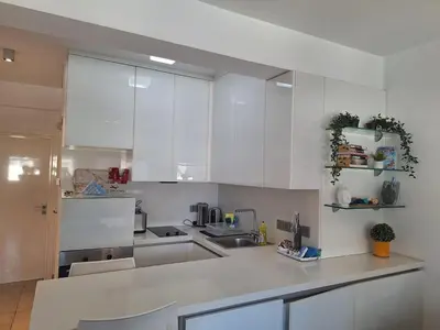 a white kitchen with white cabinets and a sink at Oceanside Living - Modern 1 bedroom in Limassol