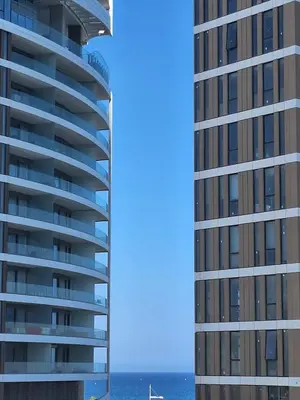 two tall buildings next to a body of water at Oceanside Living - Modern 1 bedroom in Limassol