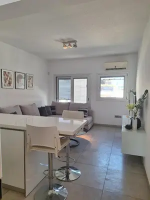 a living room with a table and a couch at Oceanside Living - Modern 1 bedroom in Limassol