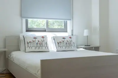 a white bed with two pillows on it with a window at Cosy & Bright European Uni Apt in Strovolos