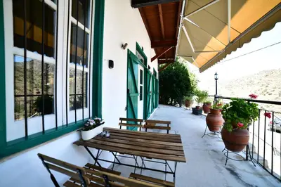 a porch with benches and potted plants on a building at Laouri Traditional 1-Bedroom in Kalopanayiotis in Kalopanayiotis