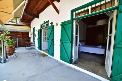 a room with green doors and a bed on a patio at Laouri Traditional 1-Bedroom in Kalopanayiotis in Kalopanayiotis