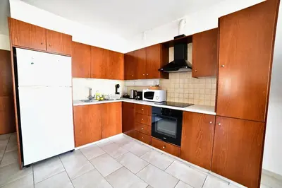 a kitchen with wooden cabinets and a white refrigerator at Laouri Traditional 2-Bedroom in Kalopanayiotis in Kalopanayiotis