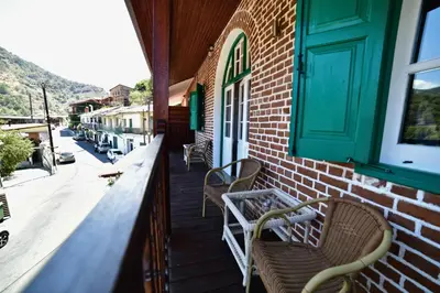 a building with two chairs on a porch at Laouri Traditional 2-Bedroom in Kalopanayiotis in Kalopanayiotis