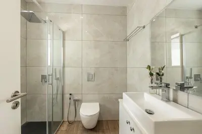 a bathroom with a shower and a toilet and a sink at Seaside Emerald in Paralimni