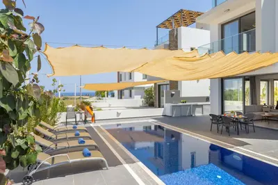 a villa with a swimming pool and a house at Seaside Emerald in Paralimni