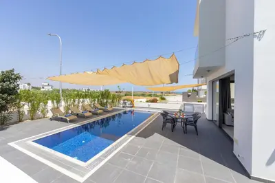 a house with a swimming pool and a patio at Seaside Emerald in Paralimni