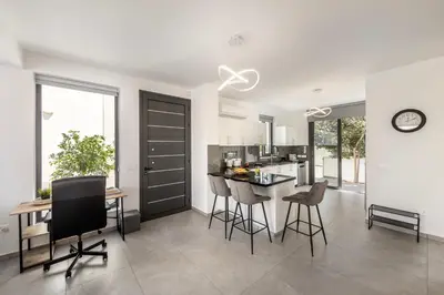 a kitchen and living room with a table and chairs at Seaside Emerald in Paralimni