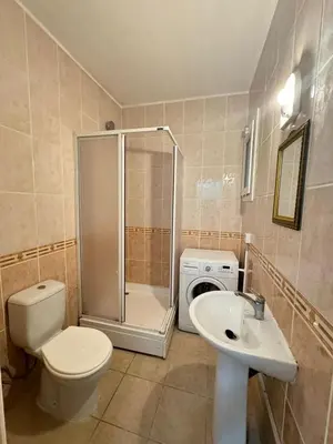 a bathroom with a toilet a sink and a washing machine at Girne Merkez Daire in Aglantzia
