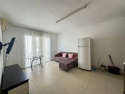 a living room with a couch and a refrigerator at Girne Merkez Daire in Aglantzia