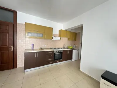 a kitchen with brown cabinets and a stove top oven at Girne Merkez Daire in Aglantzia