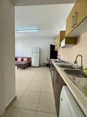 a kitchen with a sink and a living room at Girne Merkez Daire in Aglantzia