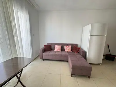 a living room with a couch and a refrigerator at Girne Merkez Daire in Aglantzia
