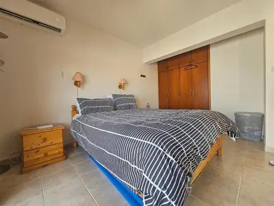 a bedroom with a bed with a black and white comforter at 1BR Apt, Huge Balcony, Walk to Nissi Beach in Ayia Napa