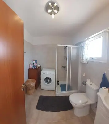 a bathroom with a toilet and a washing machine at 1BR Apt, Huge Balcony, Walk to Nissi Beach in Ayia Napa