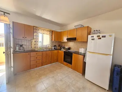 a kitchen with wooden cabinets and a white refrigerator at 1BR Apt, Huge Balcony, Walk to Nissi Beach in Ayia Napa