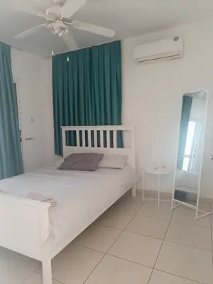 a bedroom with a white bed and a ceiling fan at Efterpis12 St. House in Paralimni