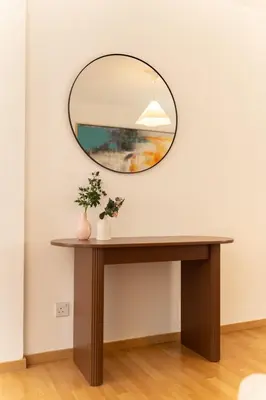 a mirror on a wall next to a table at 2 bedroom flat in city centre in Nicosia