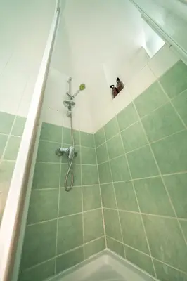 a bathroom with a shower with a green floor at Cozy 3 bedroom flat city center in Nicosia