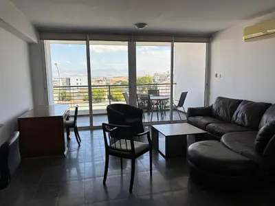 a living room with a couch and a table and chairs at Michaela's place in Aglantzia