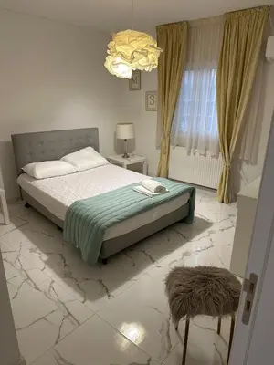a bedroom with a bed and a window and a chandelier at Modern house in Larnaca in Larnaka