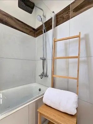 a bathroom with a bath tub and a towel on a stool at Larnaca Villa in Sophtadhes