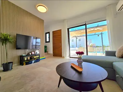 a living room with a couch and a table at Larnaca Villa in Sophtadhes
