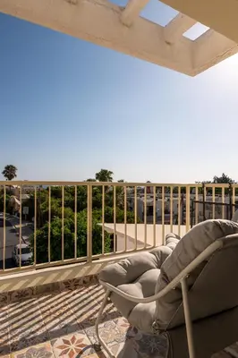 a chair on a balcony with a view of a parking lot at Seaview apartment newly renovated to high quality in Ayia Napa