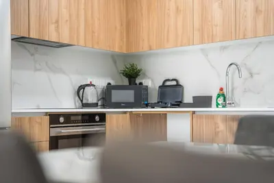 a kitchen with a counter with a microwave and a sink at Serene Gardens 2BR w Pool in Livadhia