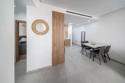 a dining room and kitchen with a table and chairs at Serene Gardens 2BR w Pool in Livadhia