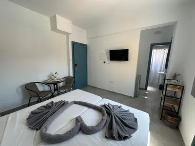a bedroom with a large white bed with a large blanket at Golden Sun Rooms - Adults Only in Ayia Napa