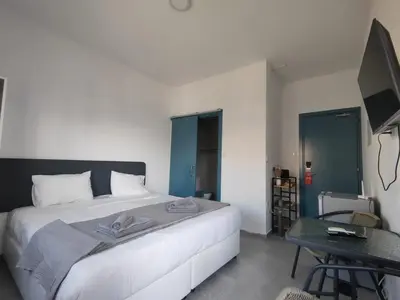a bedroom with a large white bed and a table at Golden Sun Rooms - Adults Only in Ayia Napa