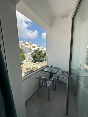 a room with a table and a glass window at Golden Sun Rooms - Adults Only in Ayia Napa