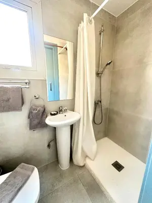a bathroom with a sink and a shower with a mirror at Golden Sun Rooms - Adults Only in Ayia Napa